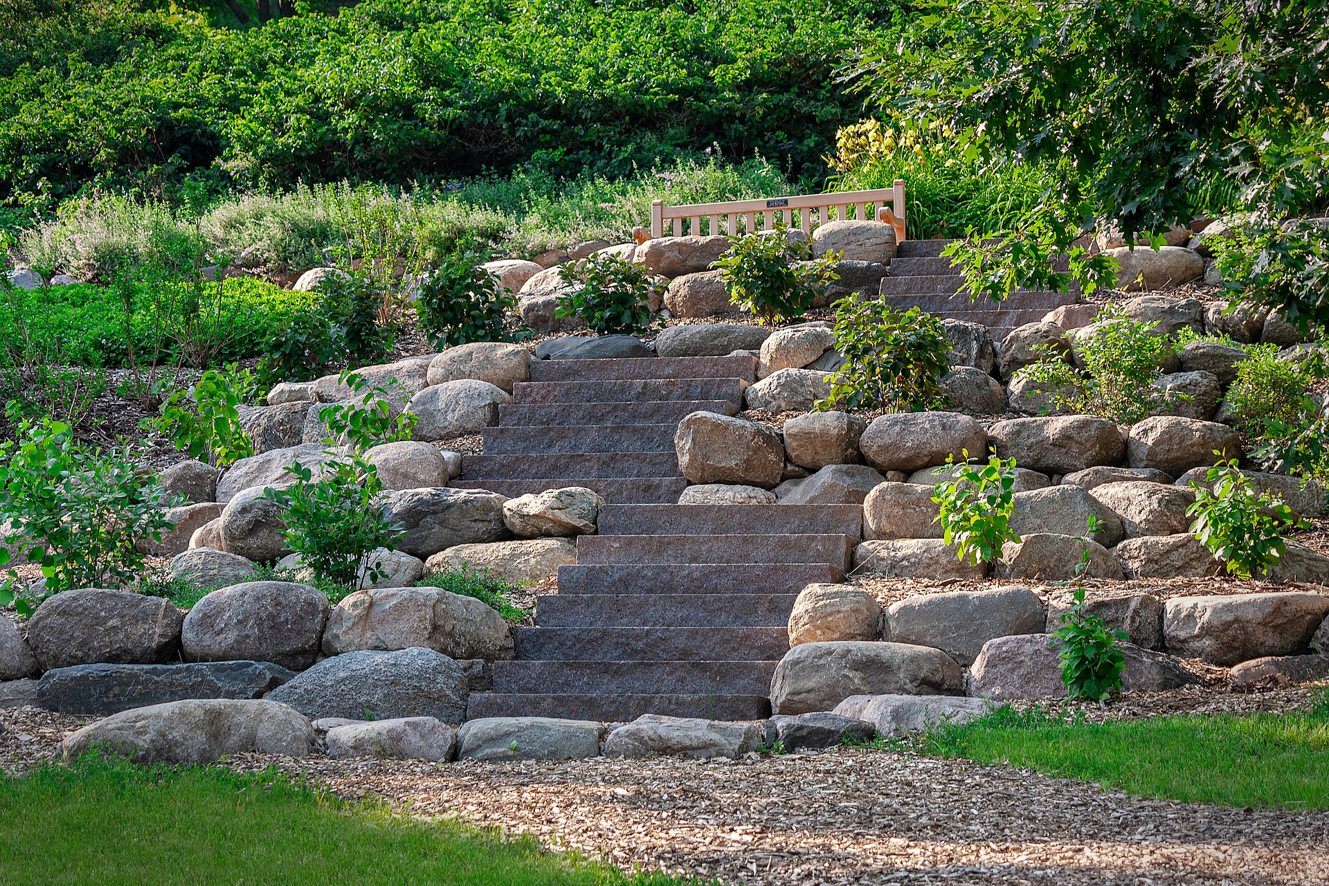Knowing the basics of how to landscape a slope yields creative results like this mix-and-match boulder and slab terrace.