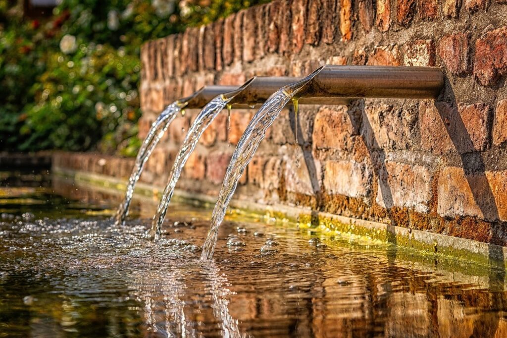 Add a unique water feature to the design, like this one made with copper pipes and brick.