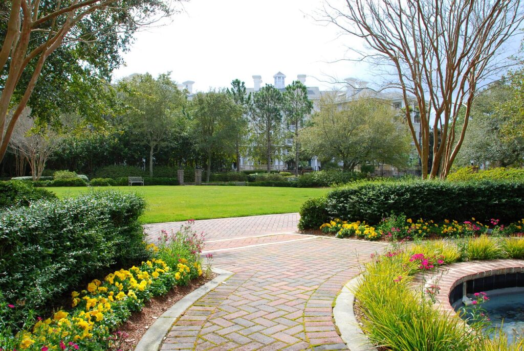 A gorgeous garden path is bordered by a water feature and seasonal flowers creating a grand display.