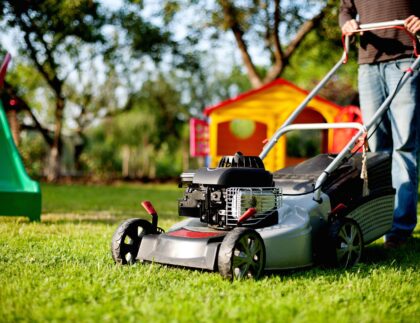 A homeowner demonstrating DIY lawn care by mowing the lawn.