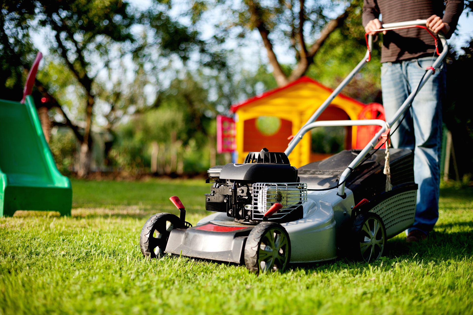 A homeowner demonstrating DIY lawn care by mowing the lawn.