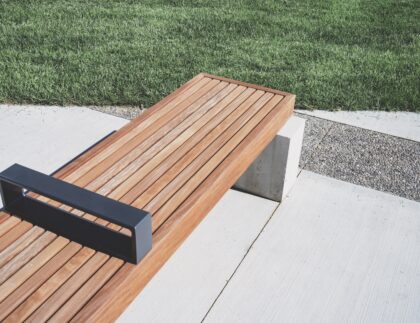 This no-frills wooden plank, metal, and concrete bench exemplifies modern landscape design.