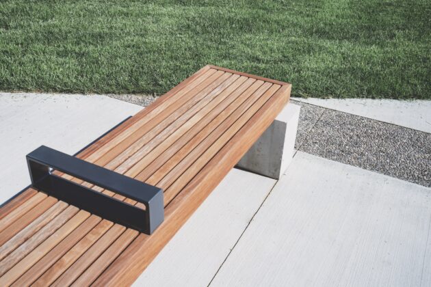 This no-frills wooden plank, metal, and concrete bench exemplifies modern landscape design.