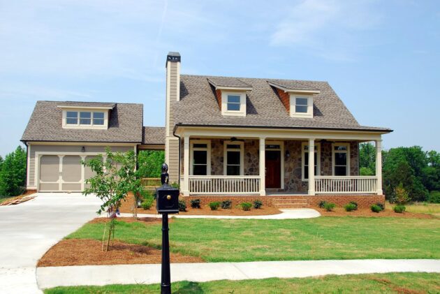 This home's front yard landscape design keeps things open and airy with an expansive lawn and a corner tree.