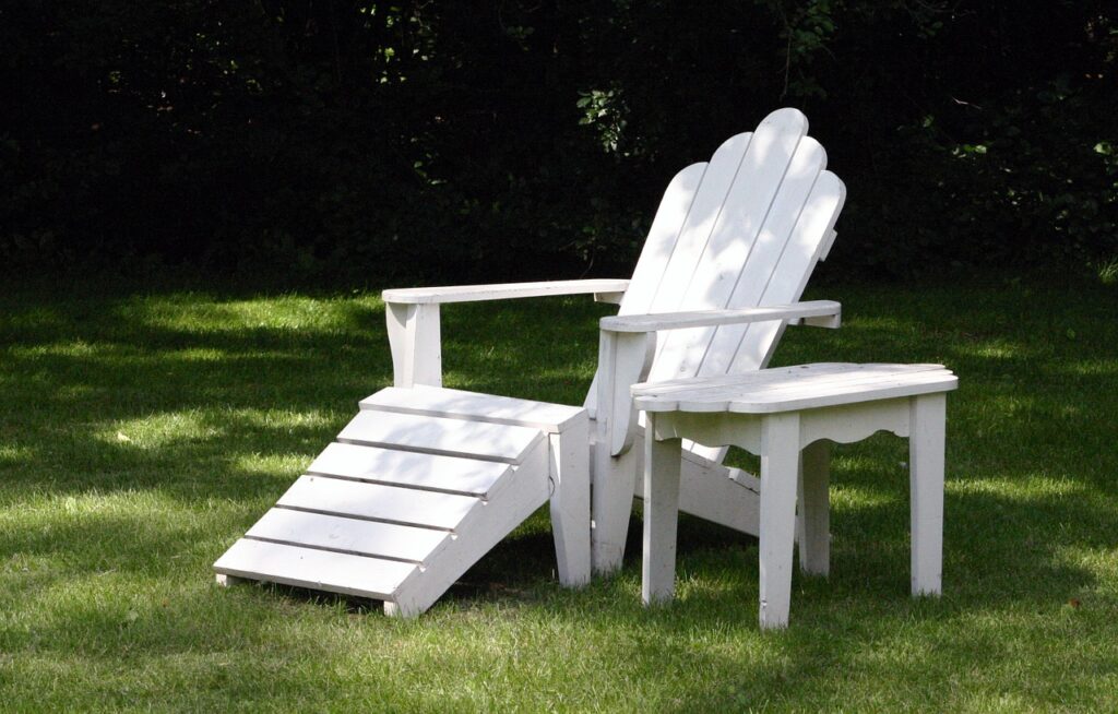 Adding a fresh coat of paint to outdoor furniture like Adirondack chairs updates the entire landscape design.